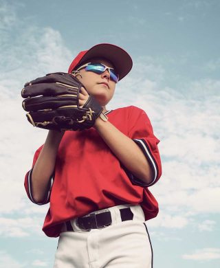 Photo of someone holding a baseball with a mitt and in a baseball uniform, used to explain shoulder injuries