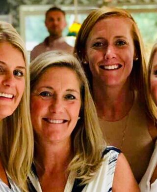 Bev Rowell and her daughters photographed smiling at the camera