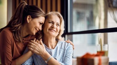 A photograph of two women holding each other close and smiling while looking off-camera, used to explain how family history of breast cancer impacts risk