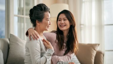 Two women sitting together on a couch with one woman's arm around the other's shoulders, used to explain BRCA gene testing