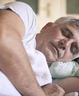 A photo of a man sleeping on his side, used to explain the best sleeping position for peripheral artery disease