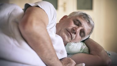 A photo of a man sleeping on his side, used to explain the best sleeping position for peripheral artery disease