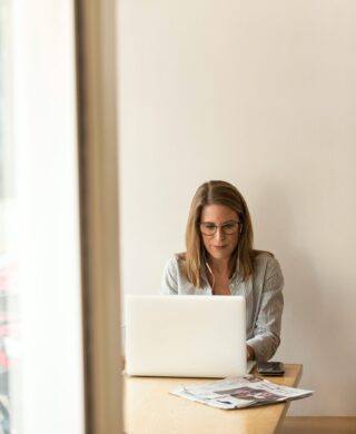 Woman sitting at table and on a laptop, used to explain the new CISNET study on mammograms